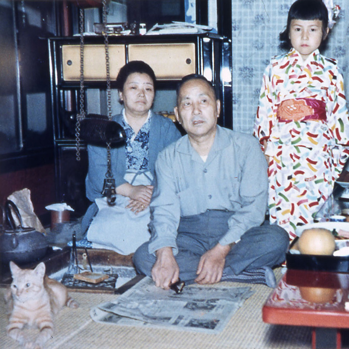 写真：創業者川合宣之夫妻と孫。川合家で飼われていた猫のチロと一緒に。（1960年代後半（昭和30年代））