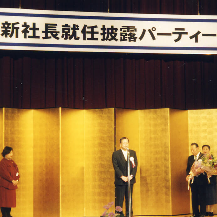 写真：現会長・川合声一が社長に就任。（1999年（平成11年））