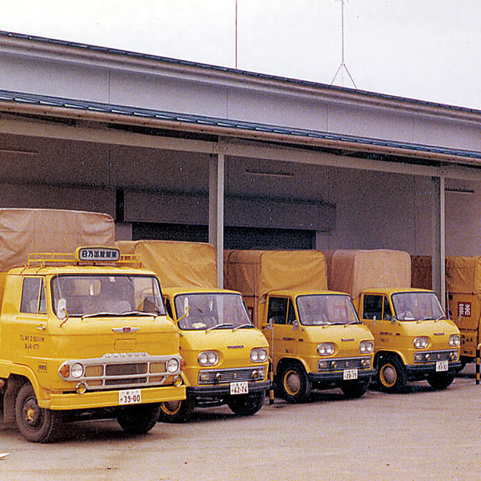 写真：自社配送便のトラック。柿山本店工場前にて。（1960年代後半（昭和40年代））